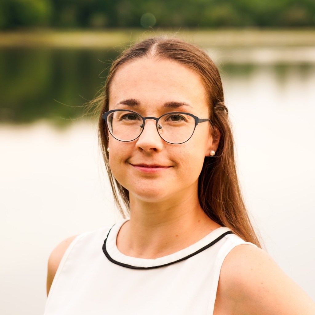Image of Mia Arter, standing in front of a lake